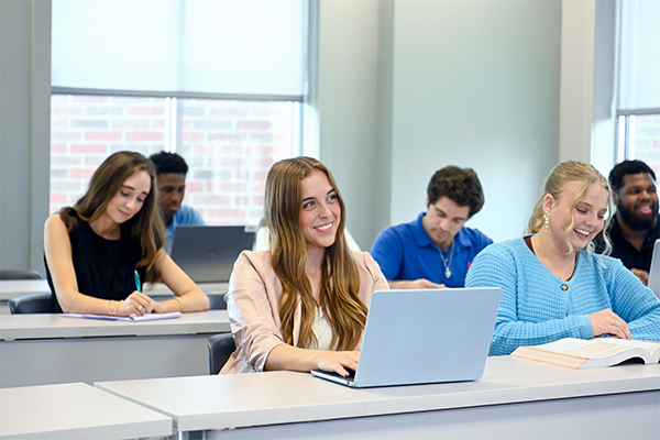 Student smiling with computer