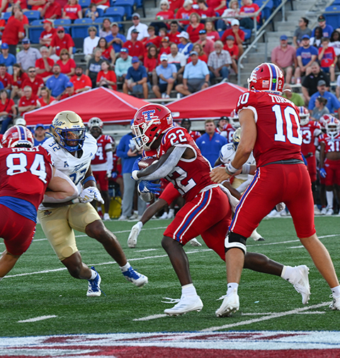 Louisiana Tech runs the football evading their opponent.