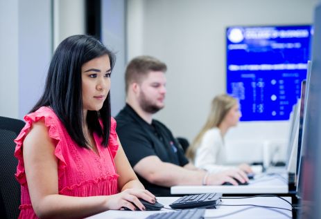 Female and male student sitting at computers in a lab