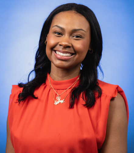 Headshot of Sydney Millage on a blue background