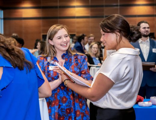 Two females speaking about resumes at a career fair