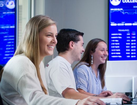 Two female students and one male students sitting at a computer in a lab