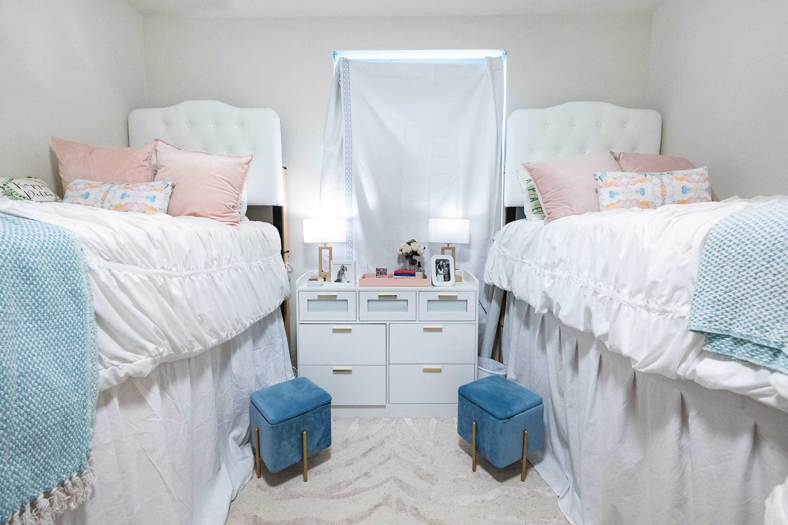 Two decorated beds inside a dorm room.