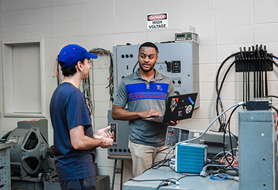 Two engineering students work int he lab.