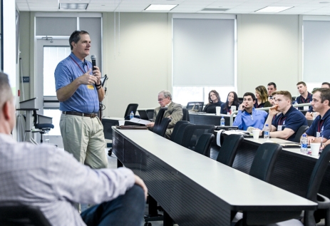 Banker teaching at the front of the classroom while student bankers listen