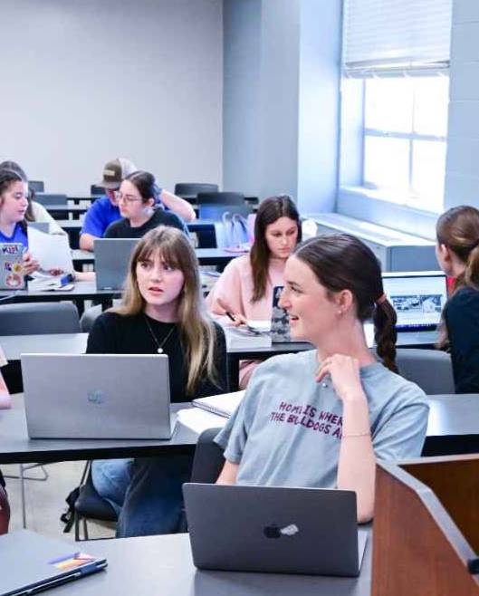 students working on laptops in classroom