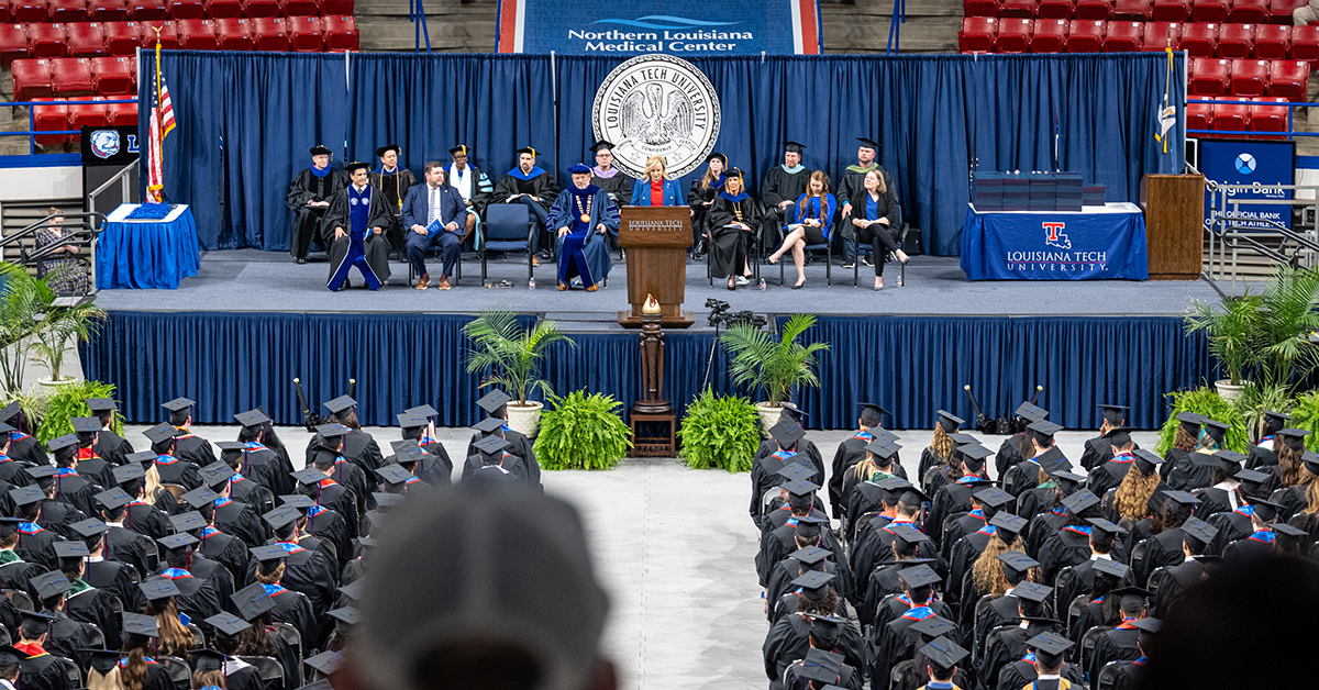 The graduation crowd watches Misti Cordell deliver her keynote speech.
