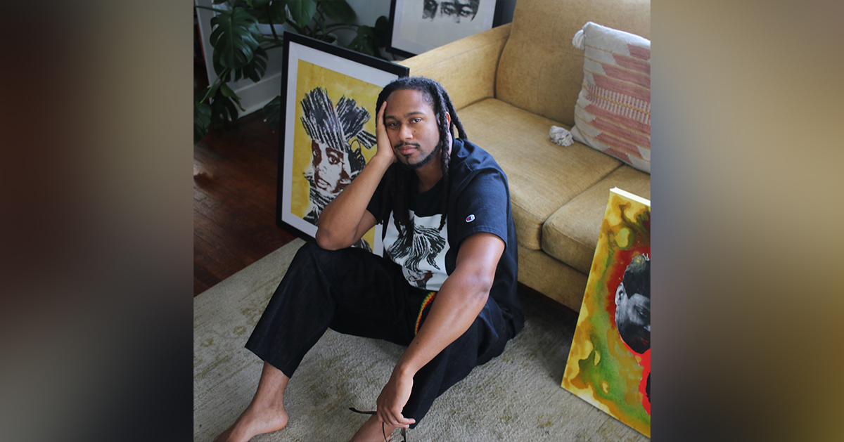 Artist John Alleyne sits on the floor surrounded by his work