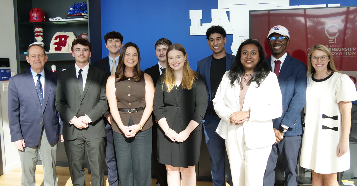 A group of people stand together and smile